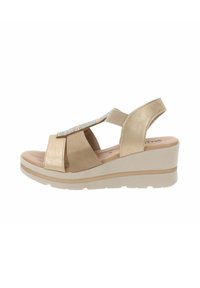Sandali con zeppa in tessuto beige e dettagli metallici. Presentano una fascia alla caviglia e una soletta imbottita per il massimo comfort.