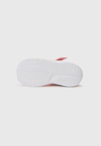 Semelle de chaussure en caoutchouc blanc avec un motif de semelle texturé. Présente un accent en tissu rose près du talon pour un design supplémentaire.