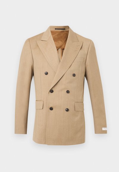 Μπεζ διπλό μπρεστ άνδρικο σακάκι με αιχμηλά πέτα, έξι σκούρα κουμπιά, τσέπες με καπάκι και λεία καφέ εσωτερική φόδρα.