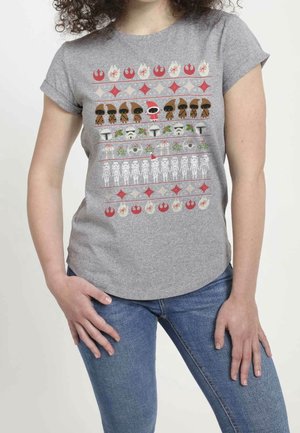 T-shirt gris à manches courtes arborant un design imprimé avec des motifs colorés de personnages et de symboles, incluant des accents rouges et blancs.