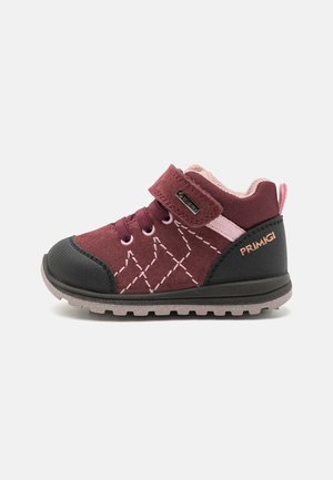 Bordeauxroter Kleinkinderstiefel mit rosa Naht, schwarzer Zehenkappe, Klettverschluss und robustem grauem Sohlenprofil, zum Tragen im Freien konzipiert.