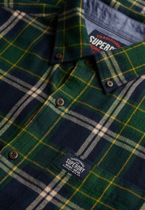 Grünes und marineblaues kariertes Flanellhemd mit gelben Akzenten, Button-Down-Kragen und einem strukturierten Stoff mit einem Logo-Patch.