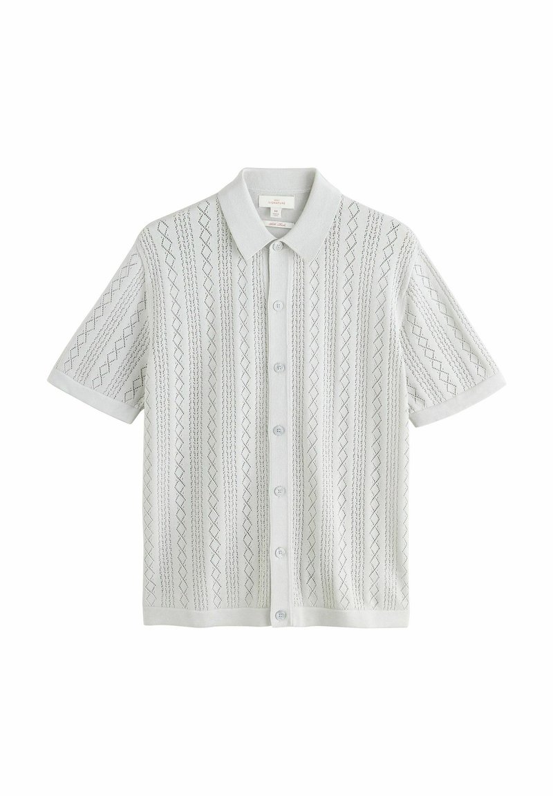 Camisa de manga corta de color gris claro con un patrón texturizado de diamantes y rayas, con botones en la parte delantera y un cuello suave.