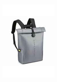 Zaino grigio con apertura superiore, dal design elegante. Realizzato in materiale impermeabile, presenta spallacci neri, una chiusura a bottone e una tasca laterale con un accento giallo.