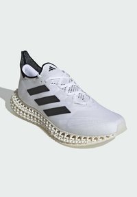 Sneaker atletica bianca con accenti neri, parte superiore in rete, design traspirante e suola spessa e testurizzata. Presenta tre strisce nere e un'etichetta per il tallone.