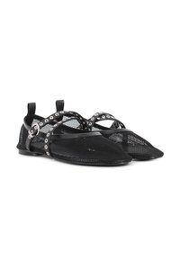 Zapatillas de malla negras con punta afilada, adornadas con tiras cruzadas que cuentan con ojales plateados. Diseño ligero con suelas planas y pestañas en el talón.