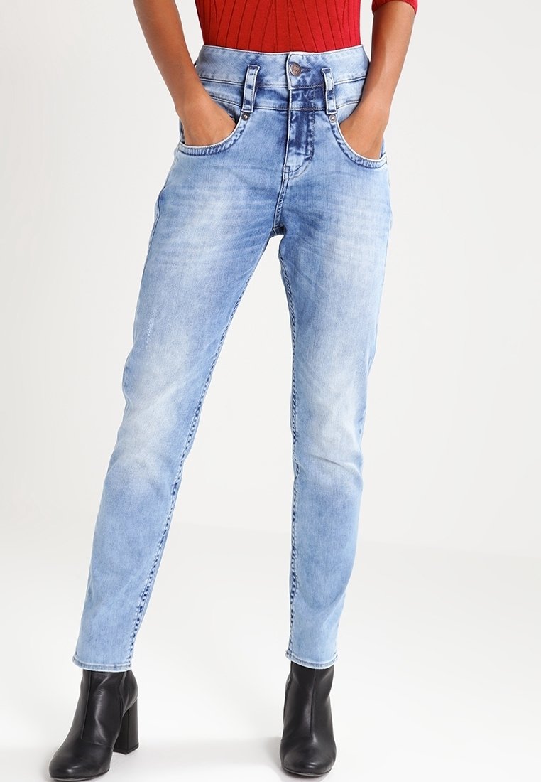 Světle modré džínové kalhoty s vysokým pasem, rovný střih nohavic, přední kapsy a vybledlý finiš. Nosit s černými kotníkovými botami.