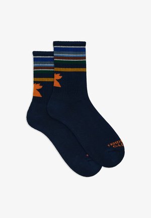 Calze blu navy con strisce multicolori in cima, presentano un silhouette di animale arancione e "TENDING" in arancione sulla punta. Morbido, tessuto a costine.