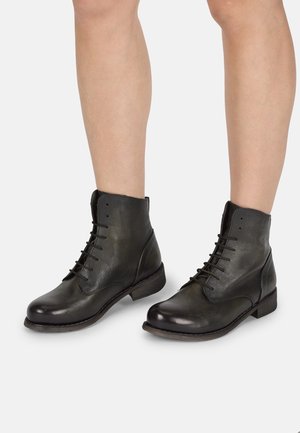 Black leather ankle boots with a smooth finish, lace-up front, rounded toe, and low block heel. Slightly distressed texture and sturdy design.
