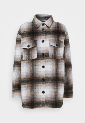 Camicia giacca a maniche lunghe con motivo a quadri marrone, nero e bianco e due tasche frontali con patta e bottoni.