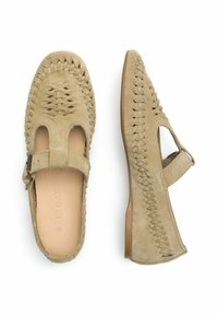 Zapatos planos de ante beige con detalle trenzado, diseño con corte y correa en el tobillo. Suela plana con mínimo agarre e interior de cuero.