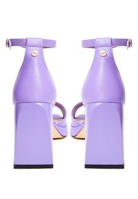Sandali alti viola con finitura lucida, tacco a blocco spesso e cinturino alla caviglia con un accento dorato sul retro.
