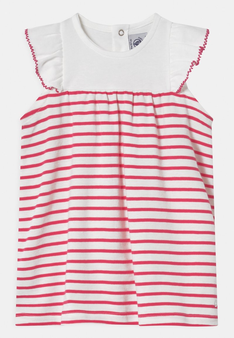 Bílý bezrukávový top s růžovými horizontálními pruhy; má volánové ramenní švy a zapínání na knoflík na zádech. Měkký bavlněný materiál.