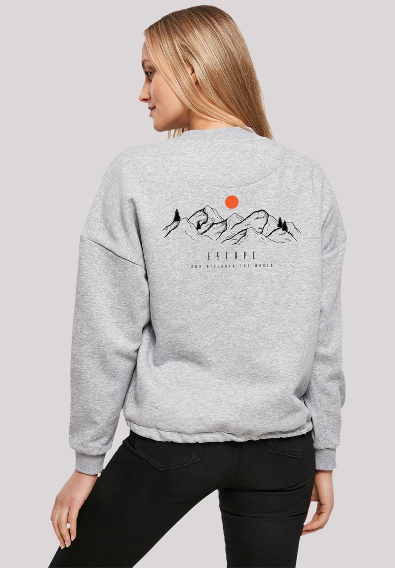 Grijze sweater met een ontspannen pasvorm, voorzien van een grafisch ontwerp van een berg en zon in zwart en oranje op de achterkant. Ribgebreide manchetten en zoom.