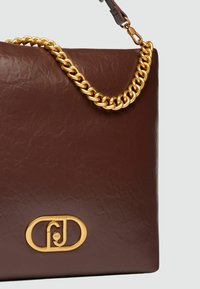 Borsa a tracolla in pelle marrone con una finitura testurizzata, dotata di una tracolla in catena dorata e un prominente logo dorato sulla parte anteriore.