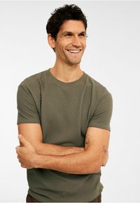 Olivengrøn, tekstureret kortærmet T-shirt med rund hals, der har et subtilt vævet mønster og afslappet pasform.