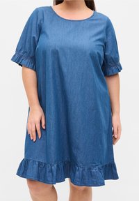 Vestido de mezclilla con cuello redondo, mangas cortas con volantes y dobladillo con volantes. La tela es de un color azul medio sólido con una textura suave.