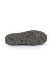 Suola di una scarpa grigia in gomma con diversi modelli di battistrada a texture e il numero di taglia 42 visibile vicino all'area dell'arco.