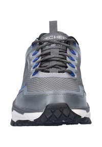 Grijze sportieve schoenen met een gemêleerde mesh bovenkant, blauwe accenten en zwarte rubberen zolen met een profielpatroon. De veters zijn grijs.