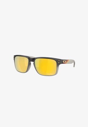 Schwarze rechteckige Sonnenbrille mit gelb verspiegelt Gläsern und grauen, verlaufenden Bügeln mit kleinem dekorativem Logo.