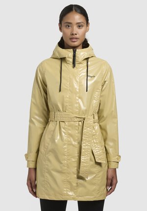 Impermeable amarillo con acabado brillante, capucha, cintura ceñida con cinturón y cordones negros. Presenta un diseño cosido y mangas abotonadas.