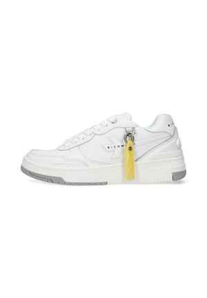 Sneaker bianca basso profilo con suola grigia, lacci e un portachiavi giallo attaccato vicino alla caviglia, marchiata "RICHMOND" sul lato.