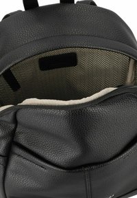 Zaino in pelle nera con apertura zip, caratterizzato da un esterno testurizzato e una fodera interna a motivo herringbone beige.