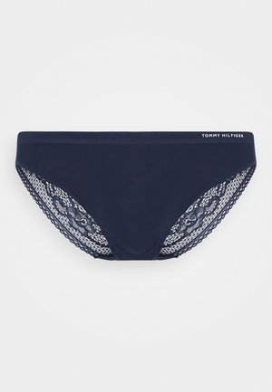Námořnické modré bikinové kalhotky se solidním předním dílem a krajkovými detaily na bocích. Obsahují logo na pásku. Měkká látka s texturovaným krajkovým vzorem.
