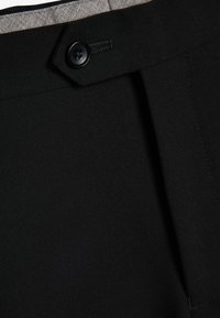 Zwarte broek met een gladde textuur, voorzien van een voorplie, knoopsluiting en een contrasterende grijze binnenvoering.