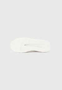 Sole di sneaker bianca con superficie texturizzata, caratterizzata da multiple scanalature per la trazione e una leggera area centrale rialzata. Design pulito e minimalista.