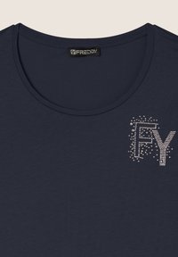 Camiseta de manga corta azul marino hecha de tela suave, con un diseño en el frontal que presenta las letras "FY" decoradas con strass y un cuello redondo.