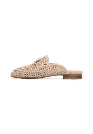 Zapato beige perforado de tipo slip-on con punta redonda, tacón bajo apilado y un adorno de hebilla decorativa en el lateral. Material de ante suave.
