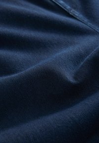 Tumesinine kangas, millel on sile tekstuur ja kerge voldiline ning kortsuline pind; valmistatud venivast ja vastupidavast materjalist, mis sobib rõivaste valmistamiseks.