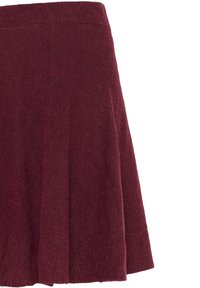 Jupe trapèze texturée rouge foncé avec taille haute et plis délicats, présentée sur fond blanc uni.