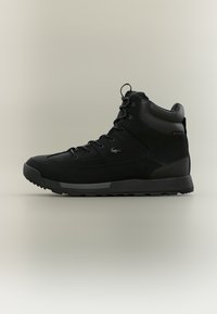 Μαύρα ψηλά αθλητικά παπούτσια με συνδυασμό λείας και υφής υλικών, με σχέδιο που κλείνει με κορδόνια, διακριτικό λογότυπο και ανθεκτική σόλα.