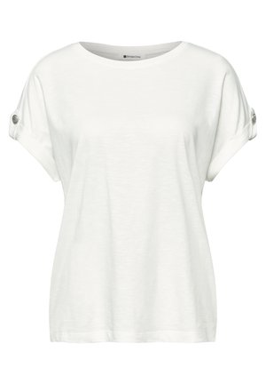 Chemise blanche à manches courtes avec col rond, poignets retroussés maintenus par des pattes de bouton, et une coupe ample et décontractée.