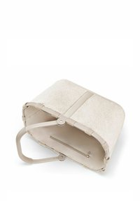 Beige Korbtasche mit einer weichen, flauschigen Textur an der Oberseite, Gummigriff und einem Reißverschlussfach innen. Robuste gewebte Seiten in neutralen Farben.