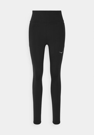 Black leggings with a high waist, made from stretchy material. Features a small white logo on the left side and side seam detailing.