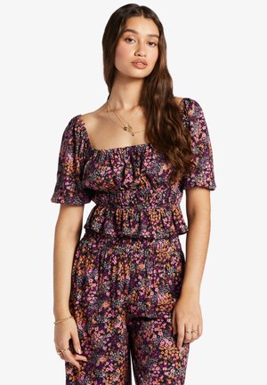 Floral print top with puff sleeves and ruffled neckline, featuring a smocked waist. Dark purple background with orange and pink flowers.
