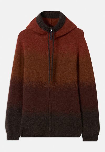 Sweatshirt de malha com fecho, apresentando um padrão degradê em tons de laranja, vermelho e castanho. Possui um colarinho alto e punhos canelados para uma textura adicional.
