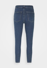 Mörkblå jeans, skinny fit, denimmaterial, med två bakfickor med texturerad yta och minimal sömnadsdetalj.