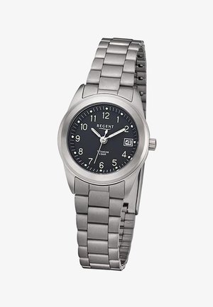 Montre bracelet en métal argenté avec cadran noir, chiffres blancs, fenêtre date à 3 heures et trois aiguilles indiquant 10 h 10 min 36 s.