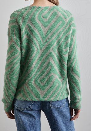 Groen en beige gebreide trui met patroon, voorzien van een zachte, pluizige textuur, een oversized pasvorm en een geometrisch ontwerp met zigzaglijnen op de achterkant.
