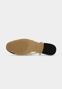 Semelle de sandale avec avant texturé marron clair et talon noir, brides transparentes visibles de côté, et nom de marque ALDO sur la semelle.