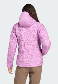 Rosa isolerad jacka med ett strukturerat mönster, huva och elastiska mudd. Har en dragsko i nederkanten och diskret logotyp på sidan.