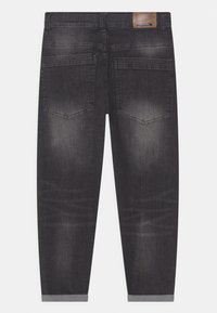 Jeans en denim gris foncé avec une finition délavée, cinq poches et des ourlets retroussés. Présente un patch de marque en cuir à la taille au dos.