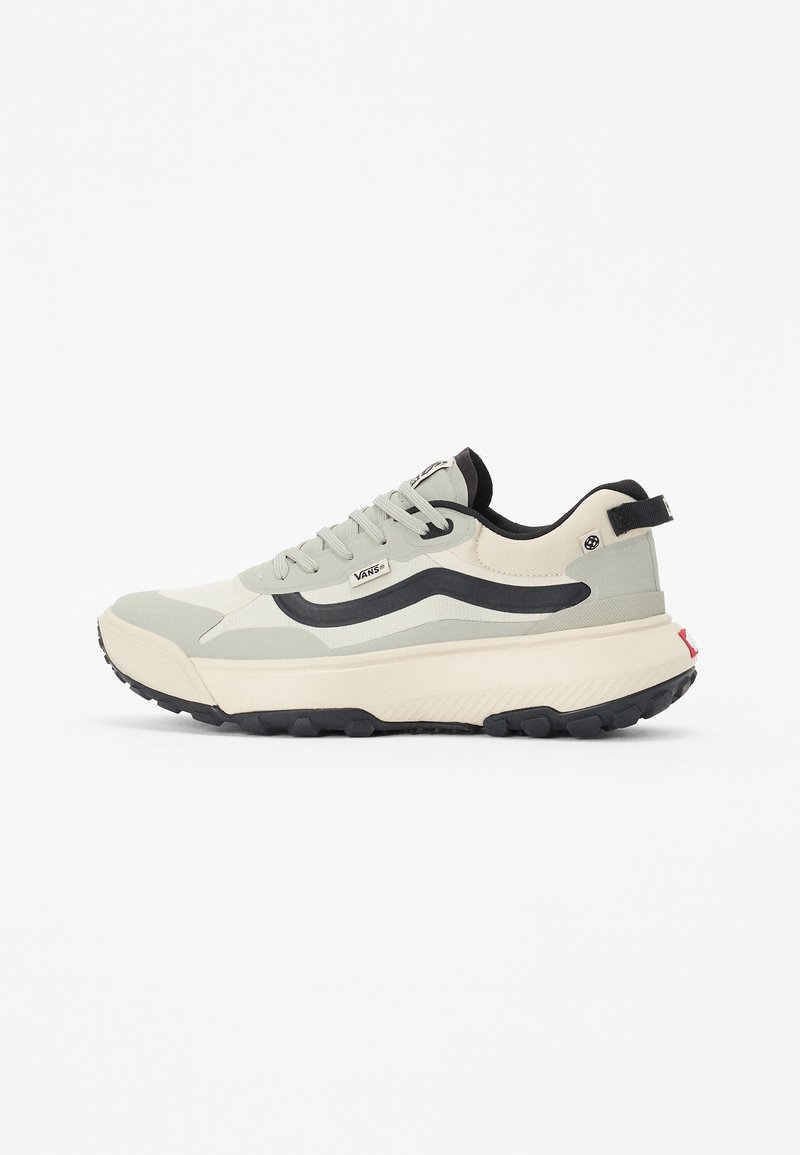 Baskets Vans gris clair et noir avec semelle épaisse, bande ondulée noire sur le côté, fermeture à lacets et languette de tirage avec logo au talon.