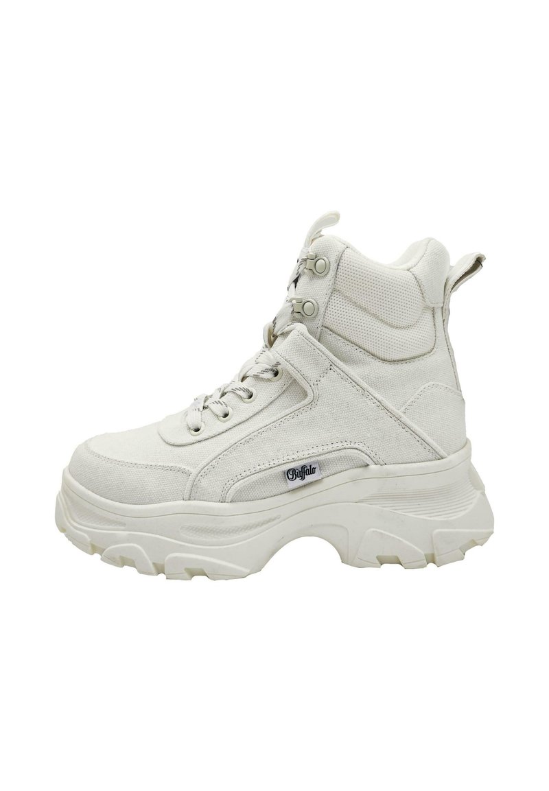White high-top sneaker with a thick rubber sole, textured canvas upper, padded collar, and metal eyelets for laces. Logo on the side.
