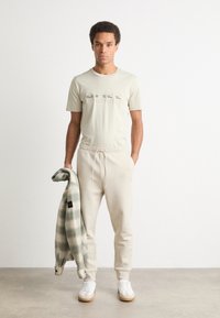 BOSS HADIKO - Spodnji deli trenirk - light beige