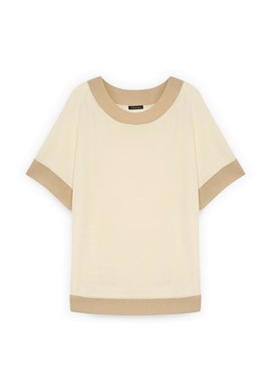 Cremefarvet kortærmet top med beige kant ved halsudskæring, ærmekanter og kant forneden, lagt fladt på hvid baggrund.